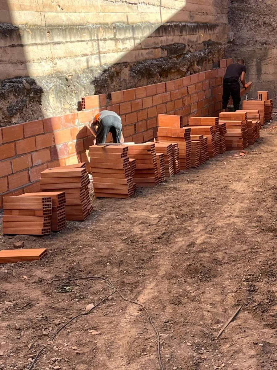 Construcción de muro de mahón junto a un talud